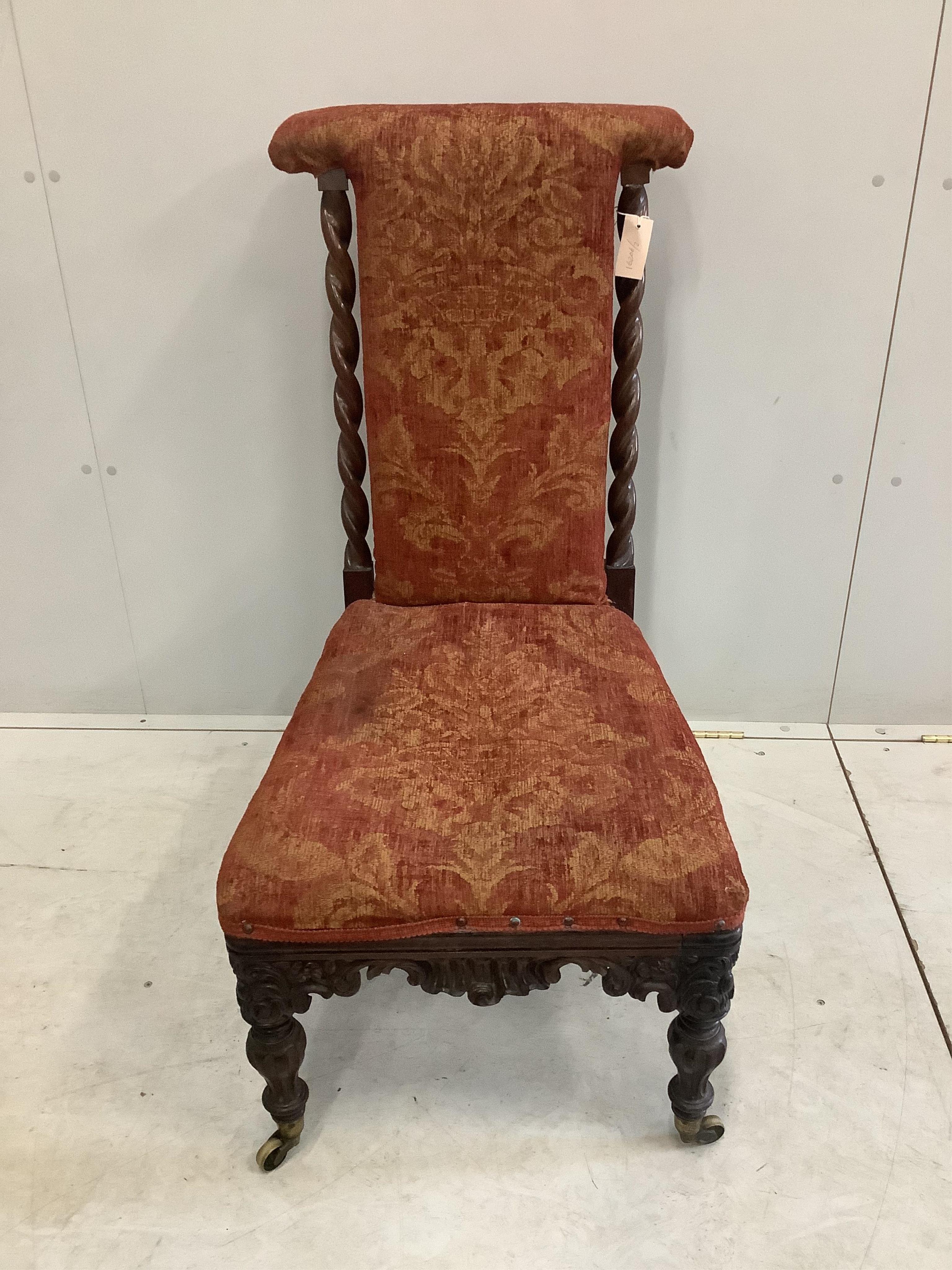 A Victorian carved rosewood prie dieu chair with later upholstery. Condition - fair